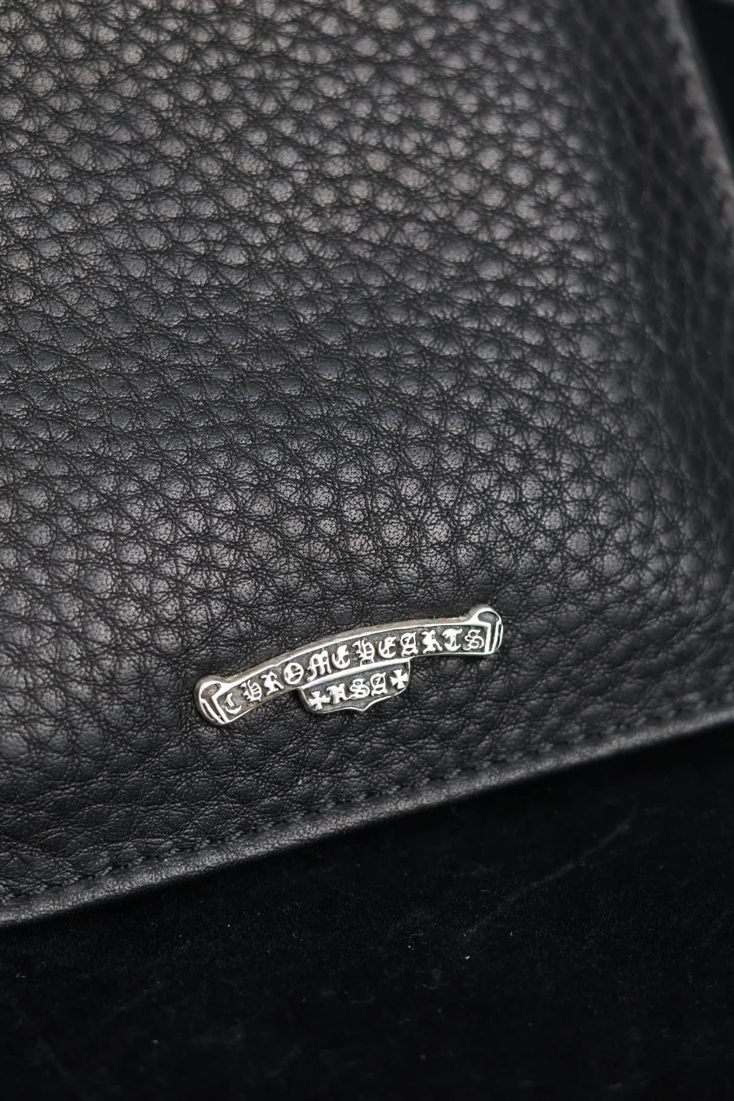 Серебряная плашка с логотипом Chrome Hearts на зернистой коже крупным планом