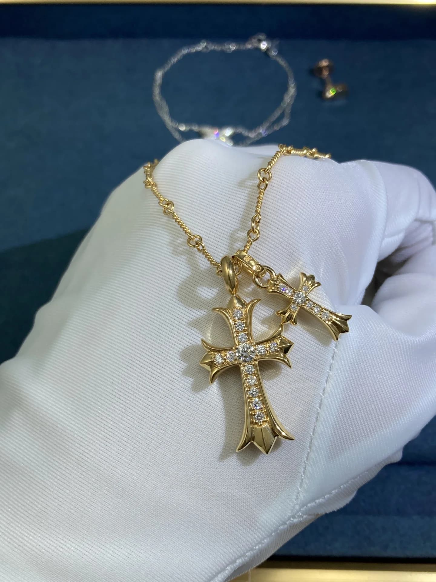 Колье Chrome Hearts с двумя подвесками-крестами из желтого золота с бриллиантами на руке в перчатке