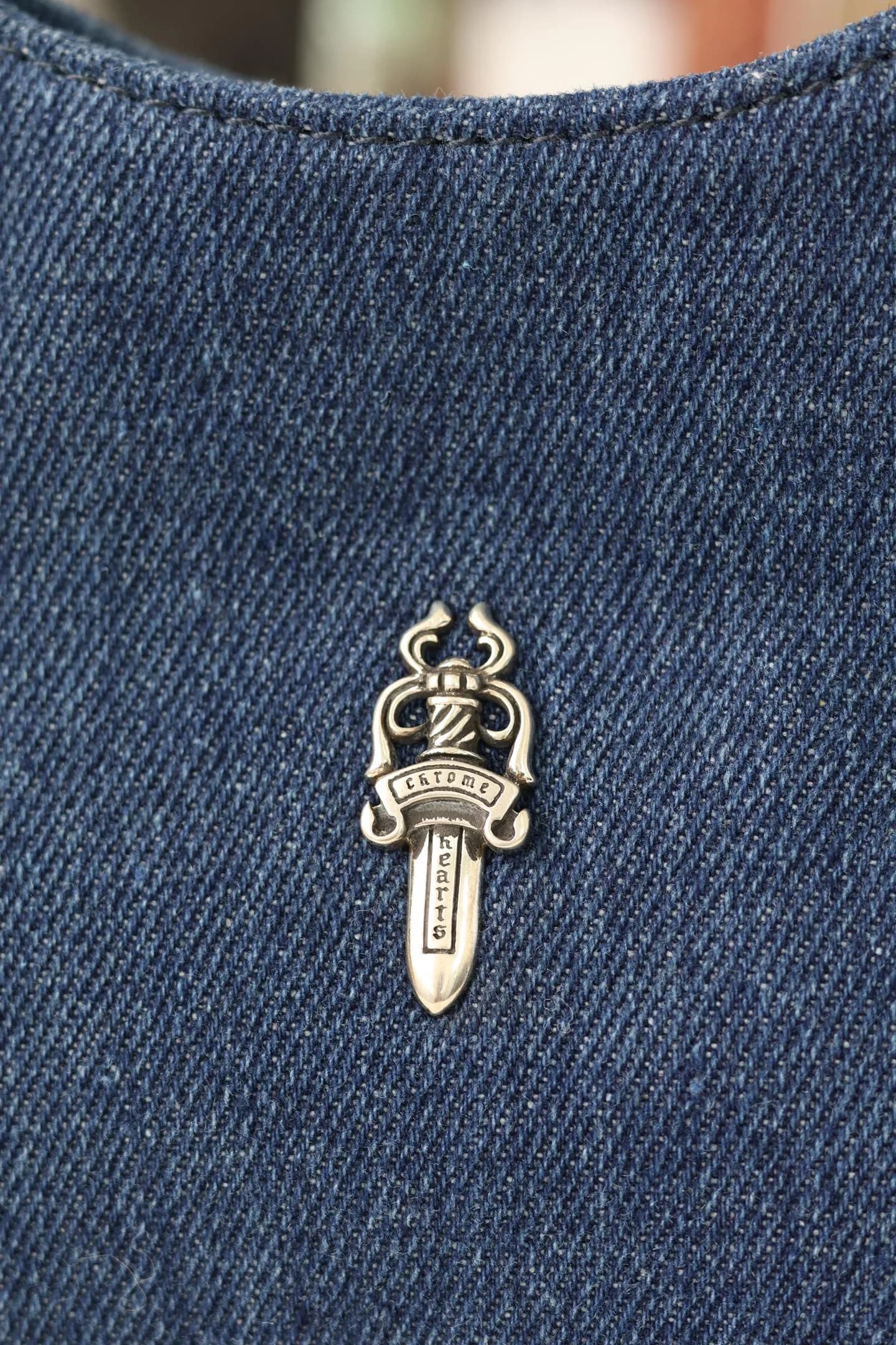 Крупный план серебряной детали Dagger из серебра 925 пробы на синем дениме