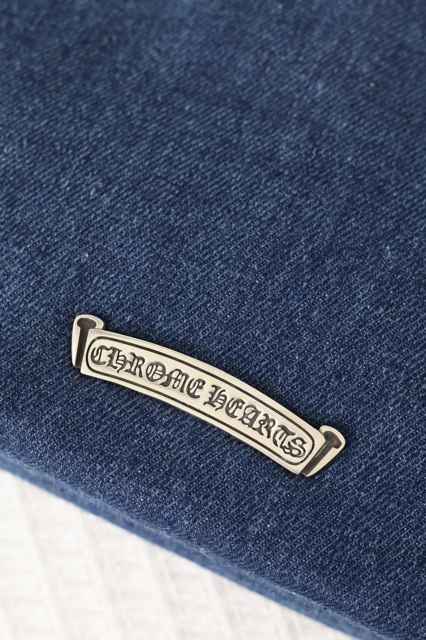 Крупный план серебряной планки с гравировкой Chrome Hearts Scroll