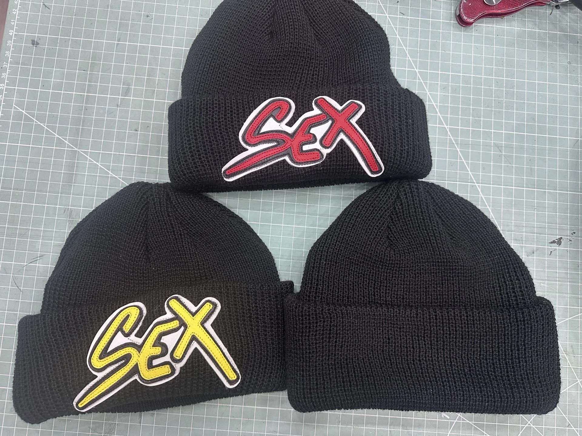Крупный план красной кожаной нашивки Sex на шапке Chrome Hearts