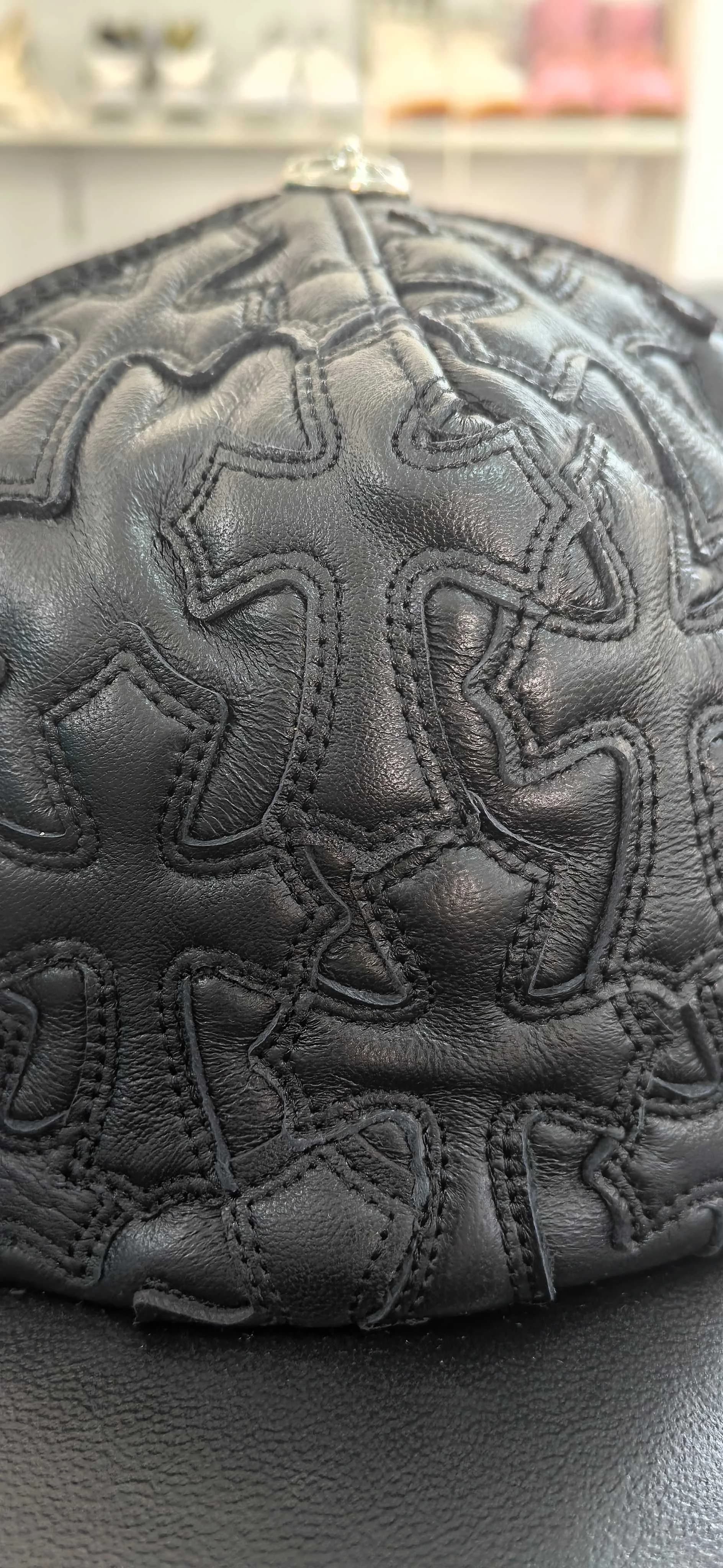 Крупный план кожаных нашивок в виде крестов на кепке Chrome Hearts
