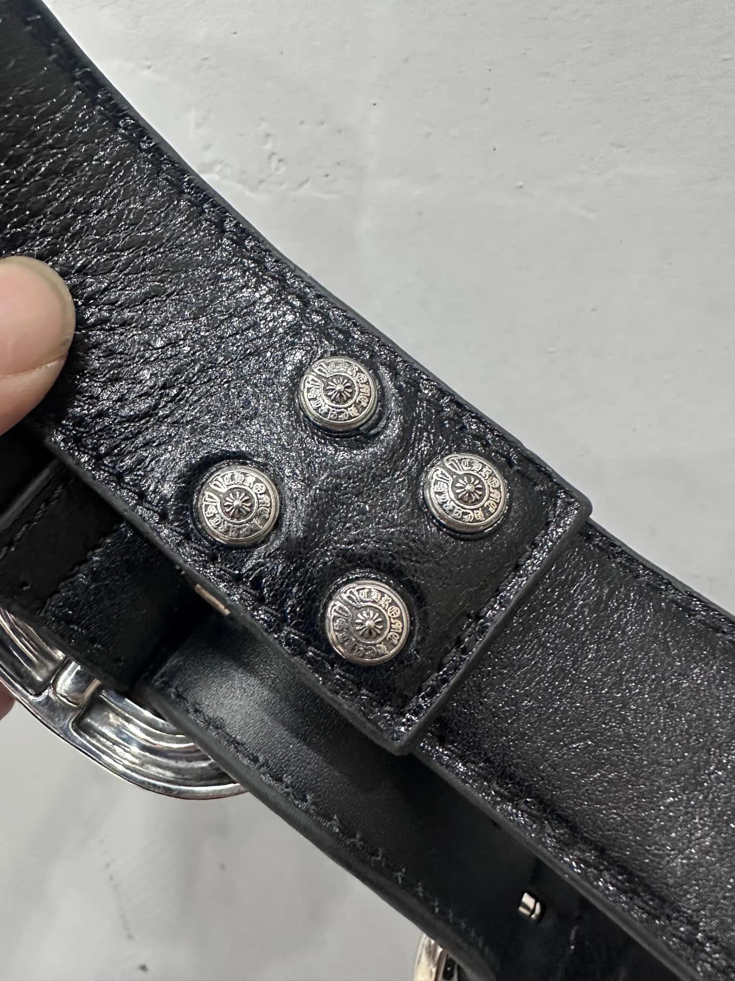 Деталь черного кожаного ремня Chrome Hearts с фирменными металлическими кнопками