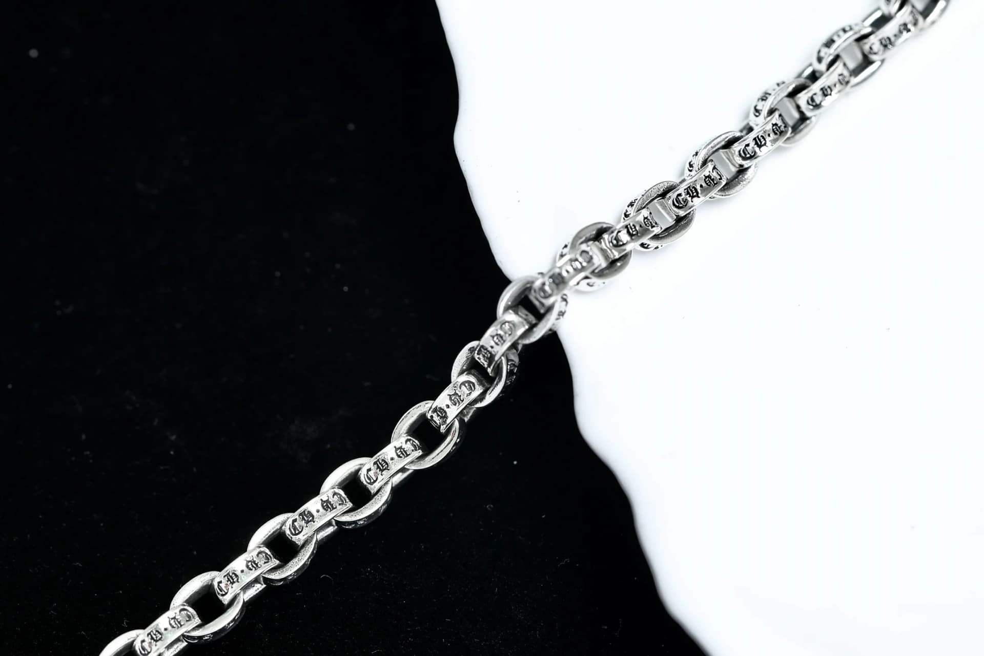 Крупный план звеньев браслета-цепи Chrome Hearts с фирменной гравировкой