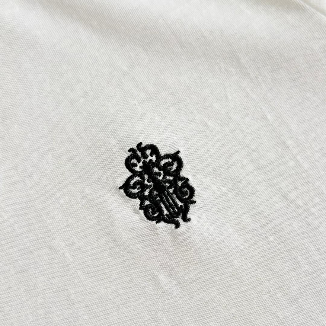 Черная фактурная вышивка на груди белой футболки Chrome Hearts