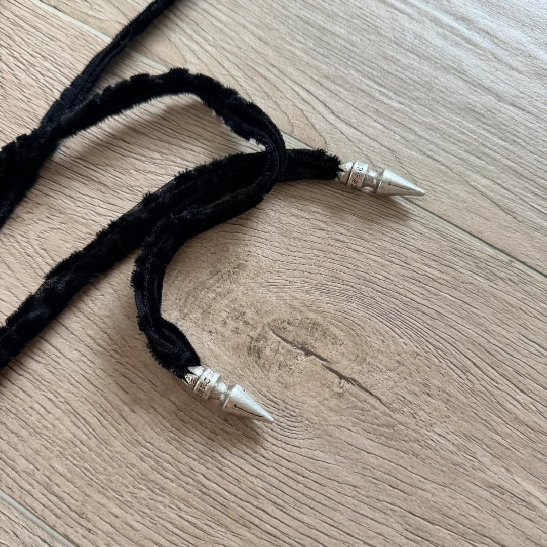 Деталь завязок черного топа Chrome Hearts с серебряными наконечниками