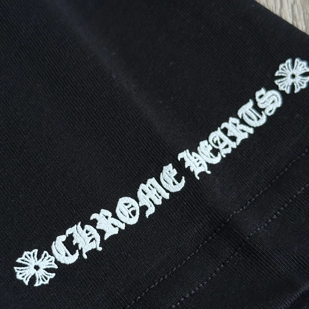 Деталь принта на рукаве черной футболки Chrome Hearts