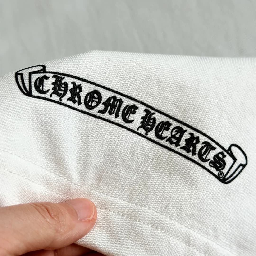 Деталь принта на рукаве белой футболки Chrome Hearts
