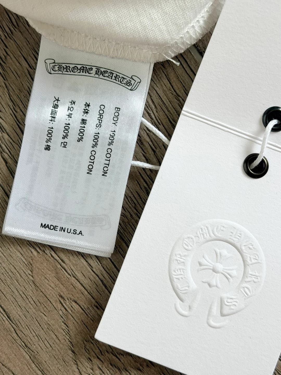 Фирменные бирки на белой футболке Chrome Hearts