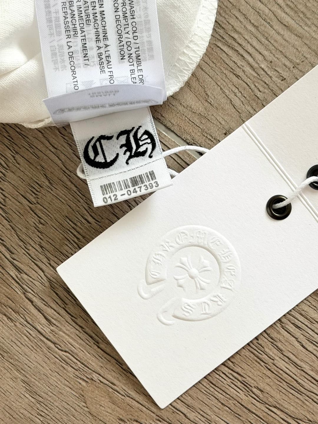 Деталь фирменной бирки белой футболки Chrome Hearts