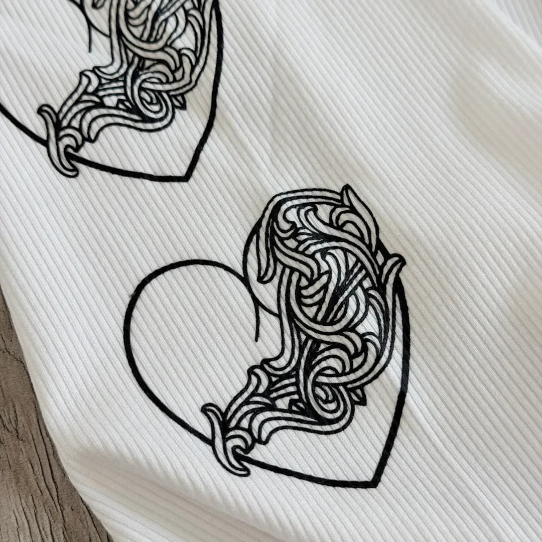 Крупный план принта в виде сердца на майке Chrome Hearts