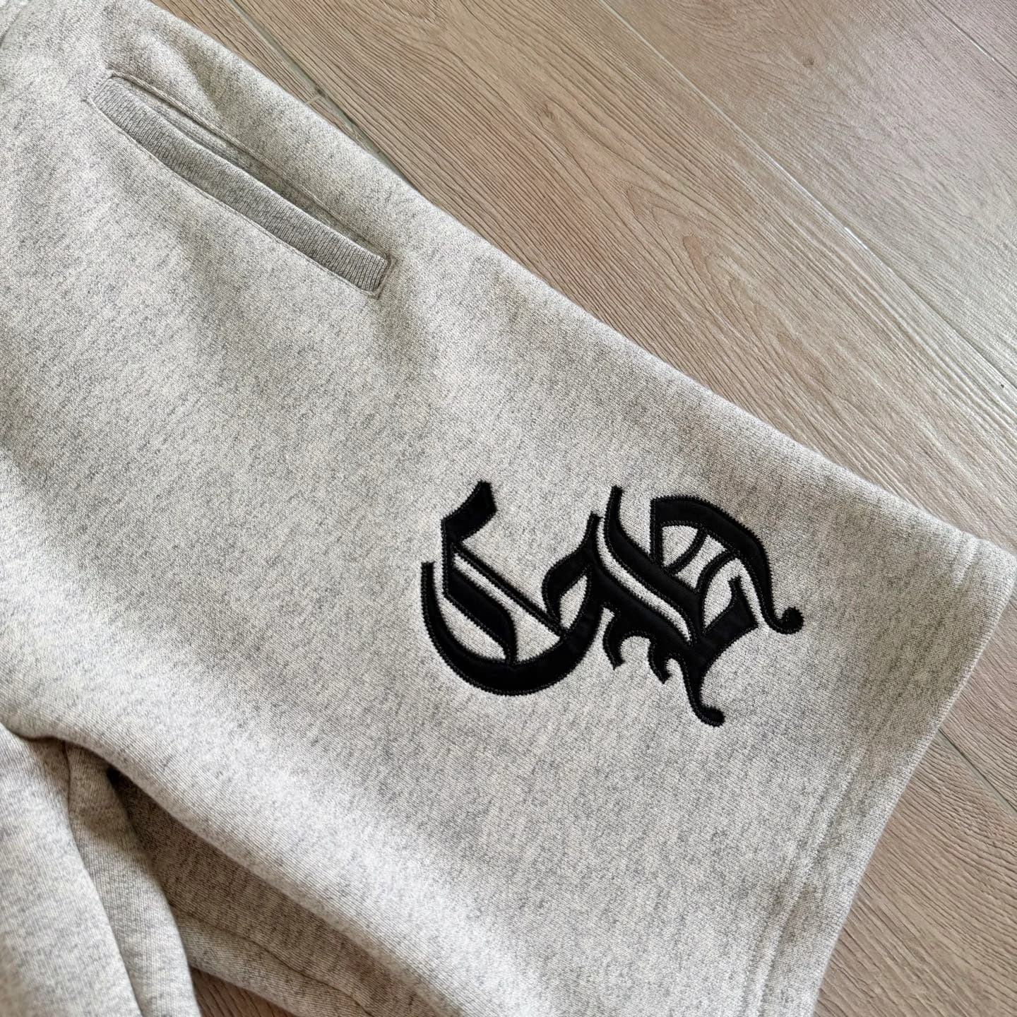 Крупный план аппликации CH на серых шортах Chrome Hearts