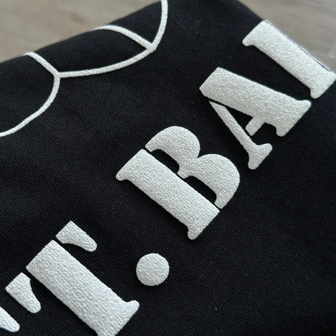 Деталь принта ST. BARTH крупным планом на черном лонгсливе Chrome Hearts