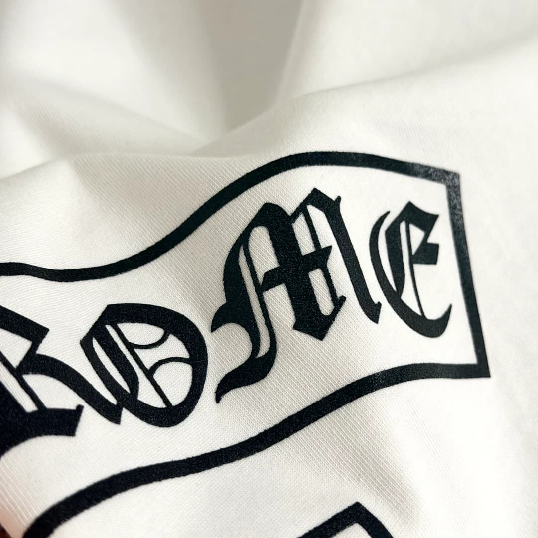 Готический шрифт на боку белой футболки Chrome Hearts
