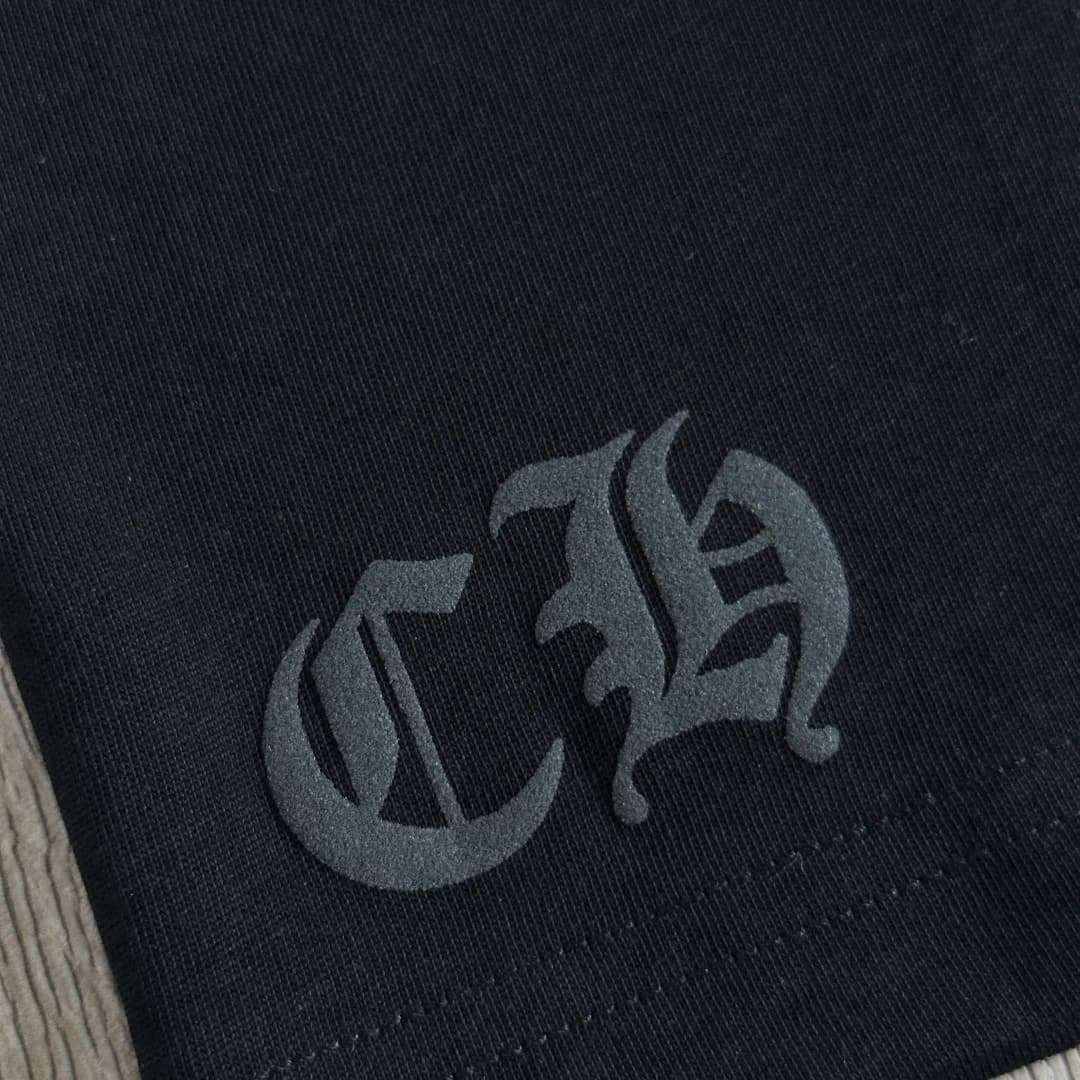 Крупный план вышивки CH на черной футболке Chrome Hearts