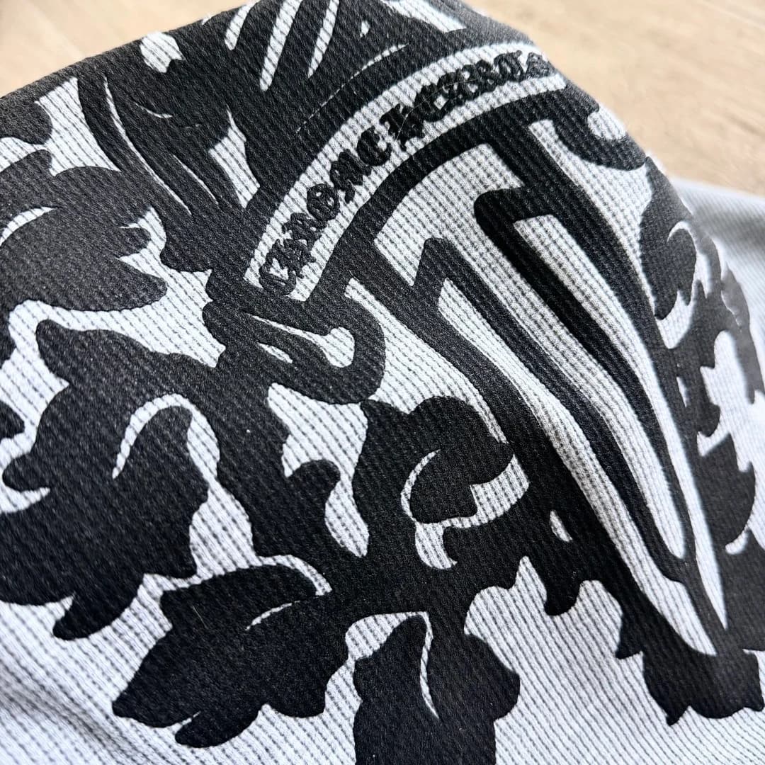 Деталь черного принта на сером вафельном трикотаже Chrome Hearts