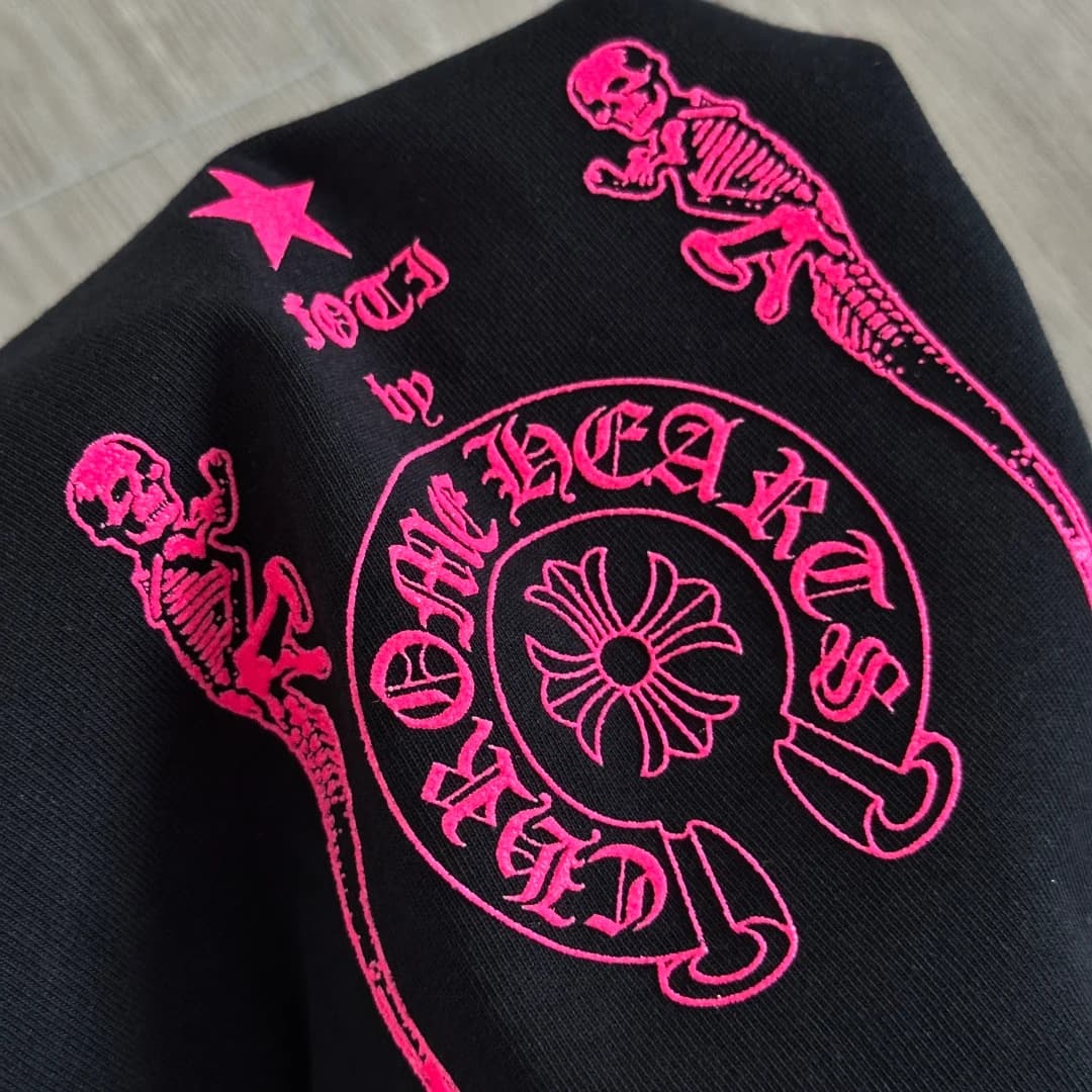 Деталь неоново-розового принта на черной футболке Chrome Hearts