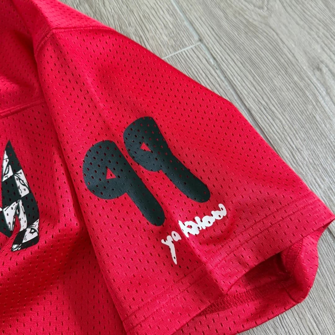 Деталь рукава с принтом номера 99 на красной футболке-джерси Chrome Hearts