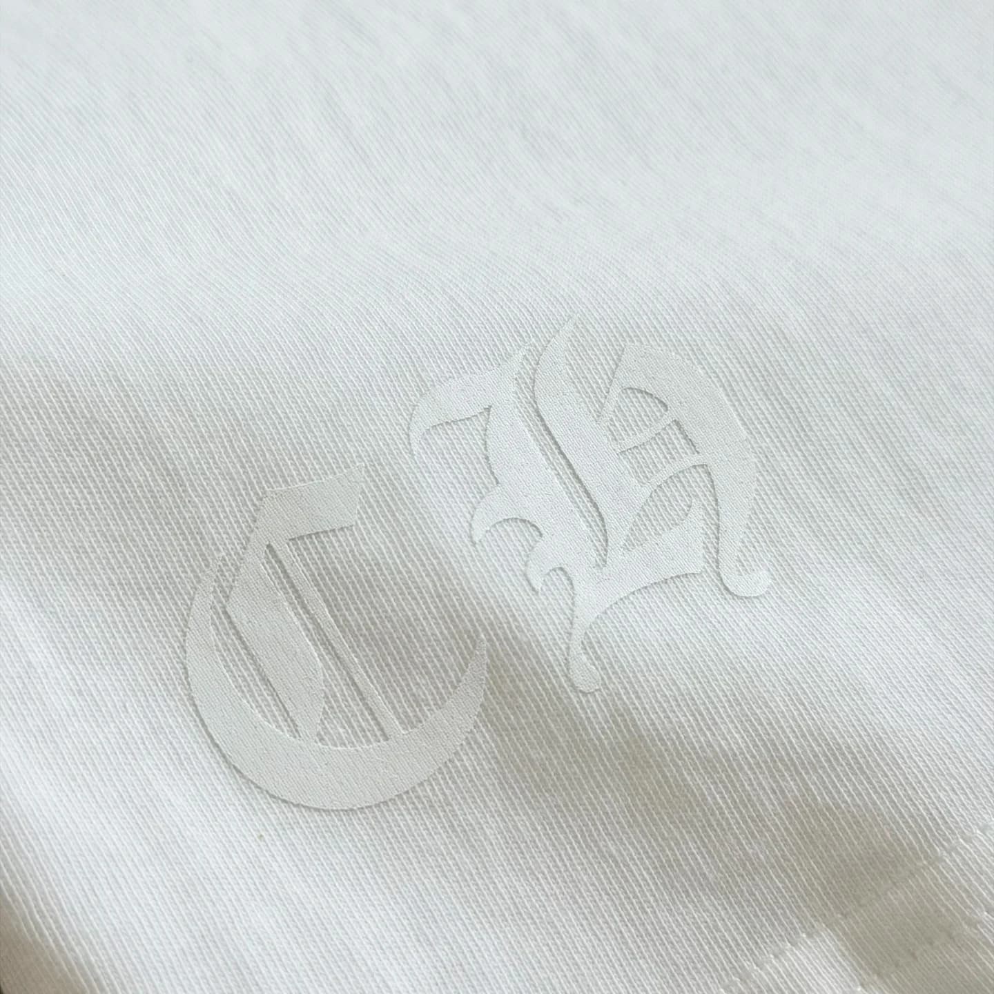 Тональный белый принт CH на подоле лонгслива Chrome Hearts