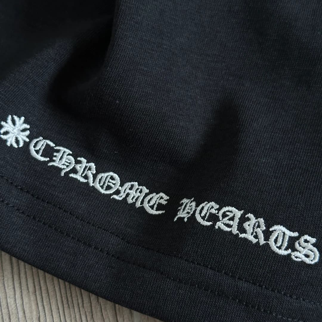 Вышивка названия бренда на нижнем крае черного лонгслива Chrome Hearts GRP Y