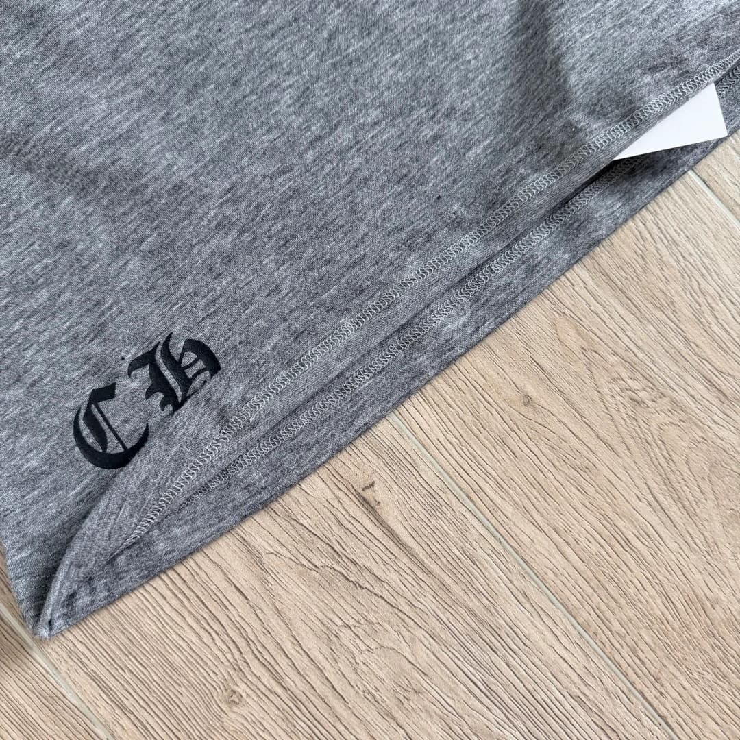 Нижний край серой футболки Chrome Hearts с монограммой CH