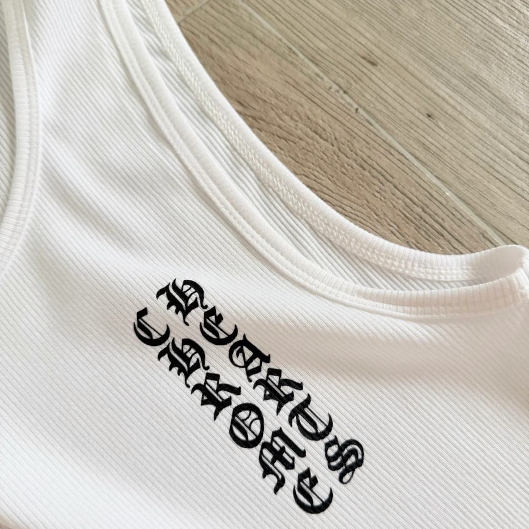Деталь выреза и принта с готическим логотипом Chrome Hearts