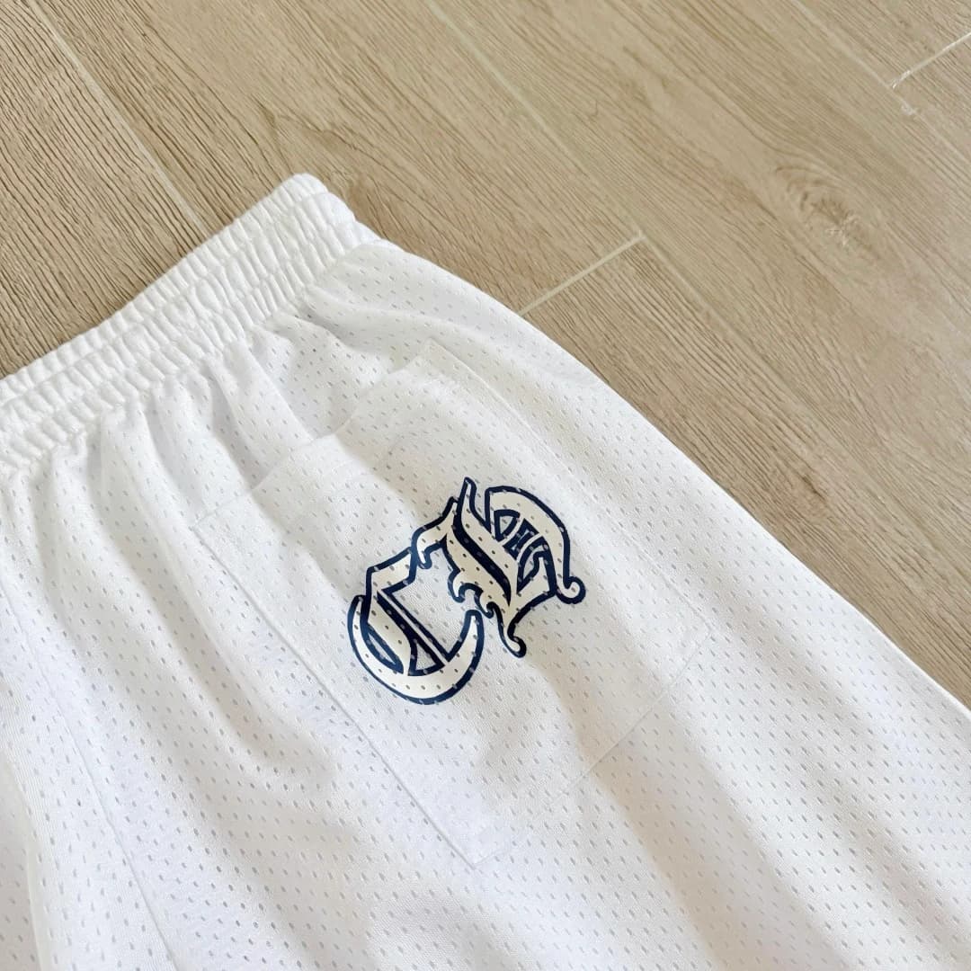 Крупный план монограммы CH на белых спортивных штанах Chrome Hearts