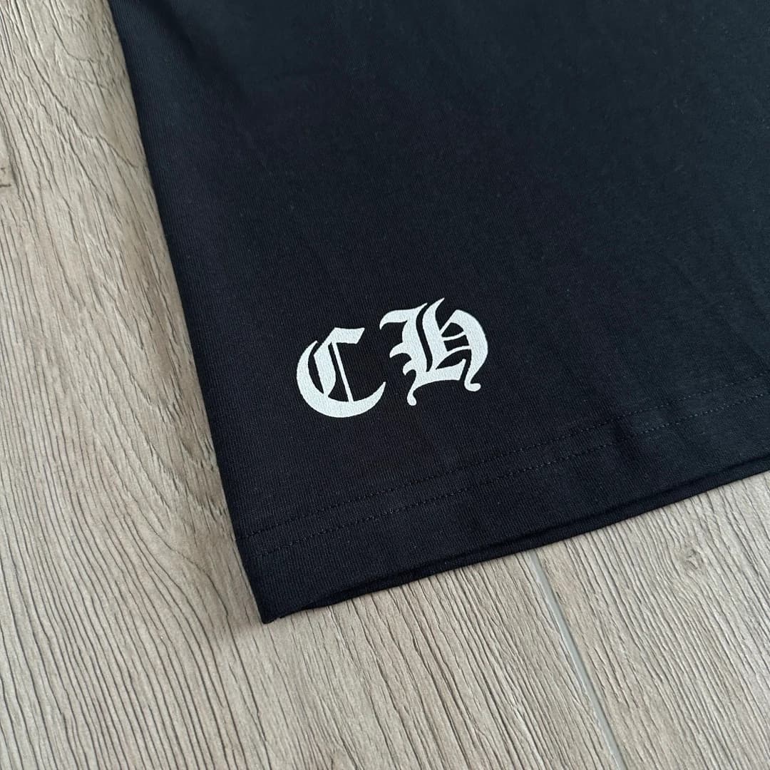 Вышивка CH на нижнем крае черной футболки
