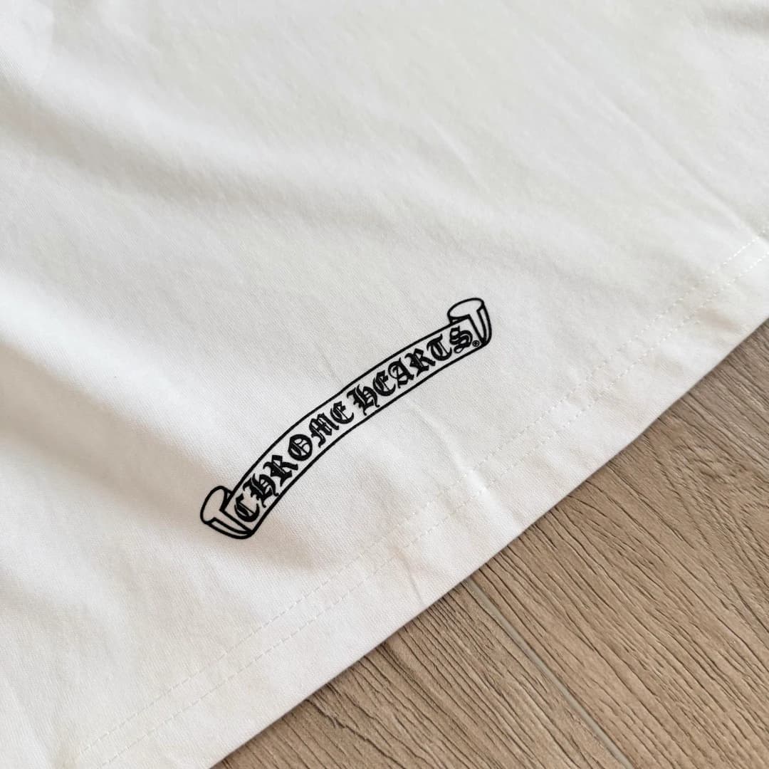 Принт-свиток по нижнему краю белой футболки Chrome Hearts