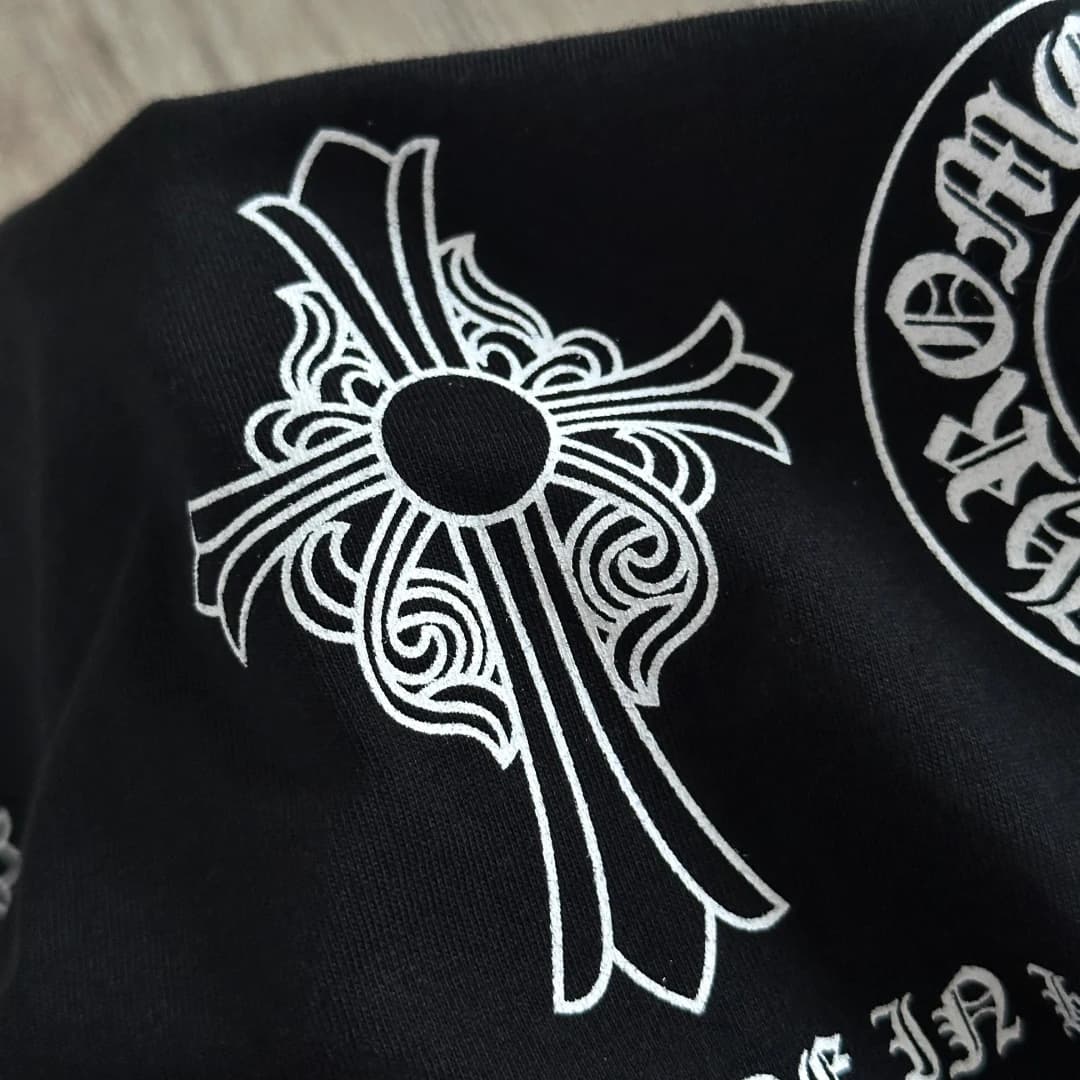 Крупный план принта с геральдическим крестом на черной футболке Chrome Hearts