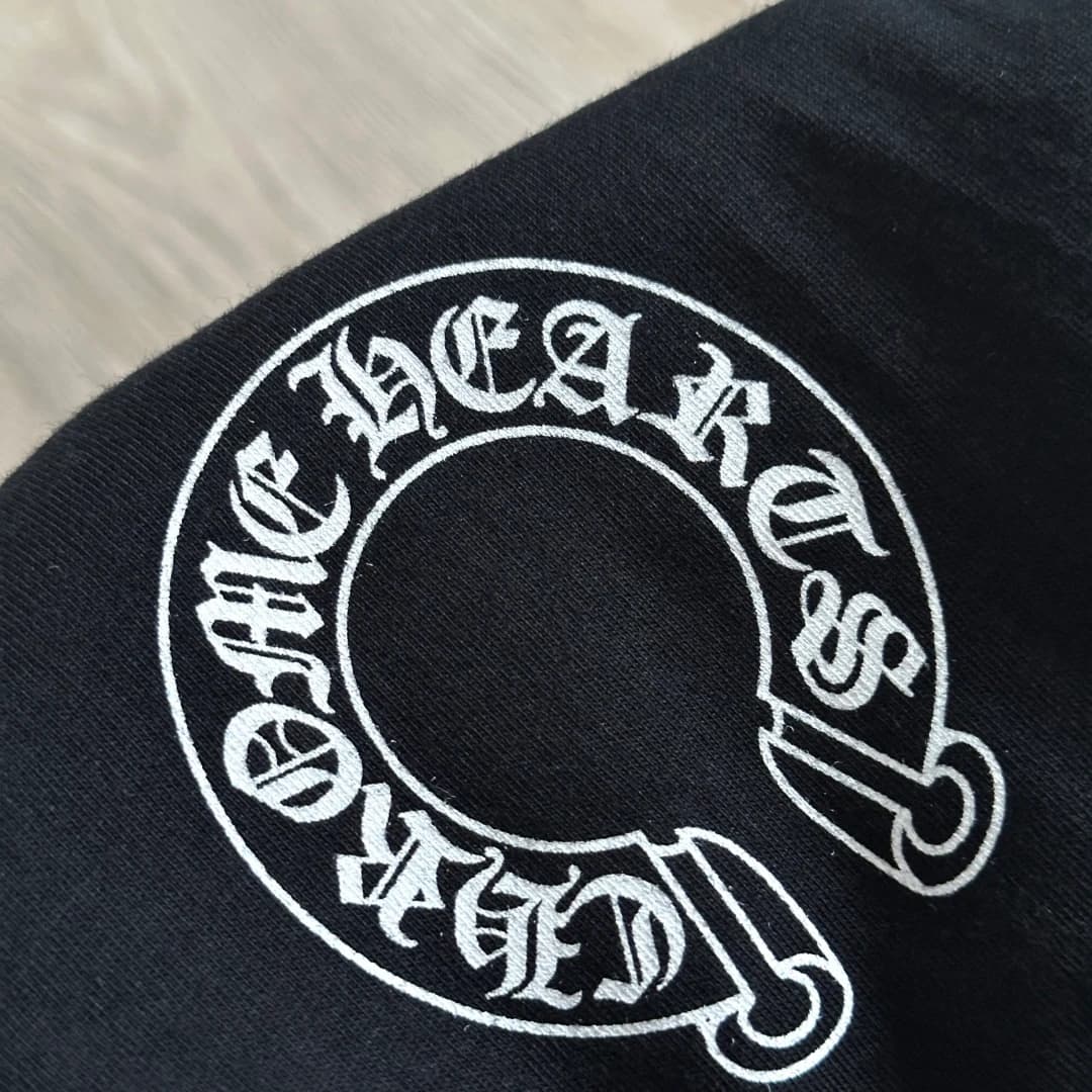 Принт в виде подковы Chrome Hearts на черной футболке крупным планом