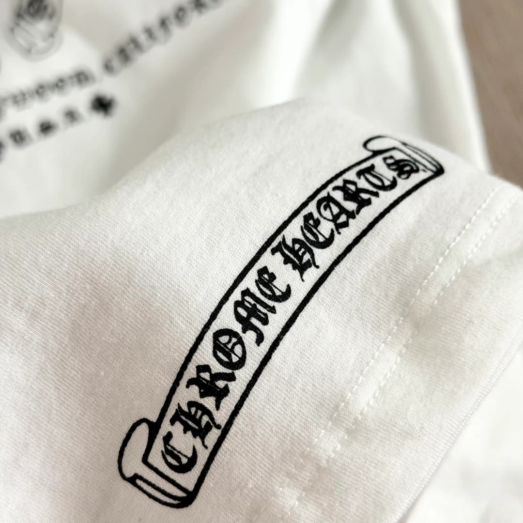 Деталь принта с логотипом Chrome Hearts на белой футболке