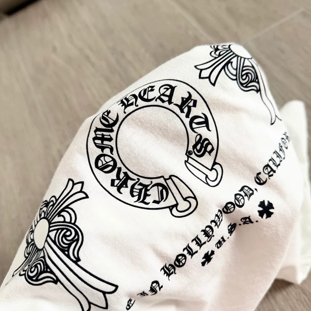 Крупный план принта с подковой и крестом на белой футболке Chrome Hearts