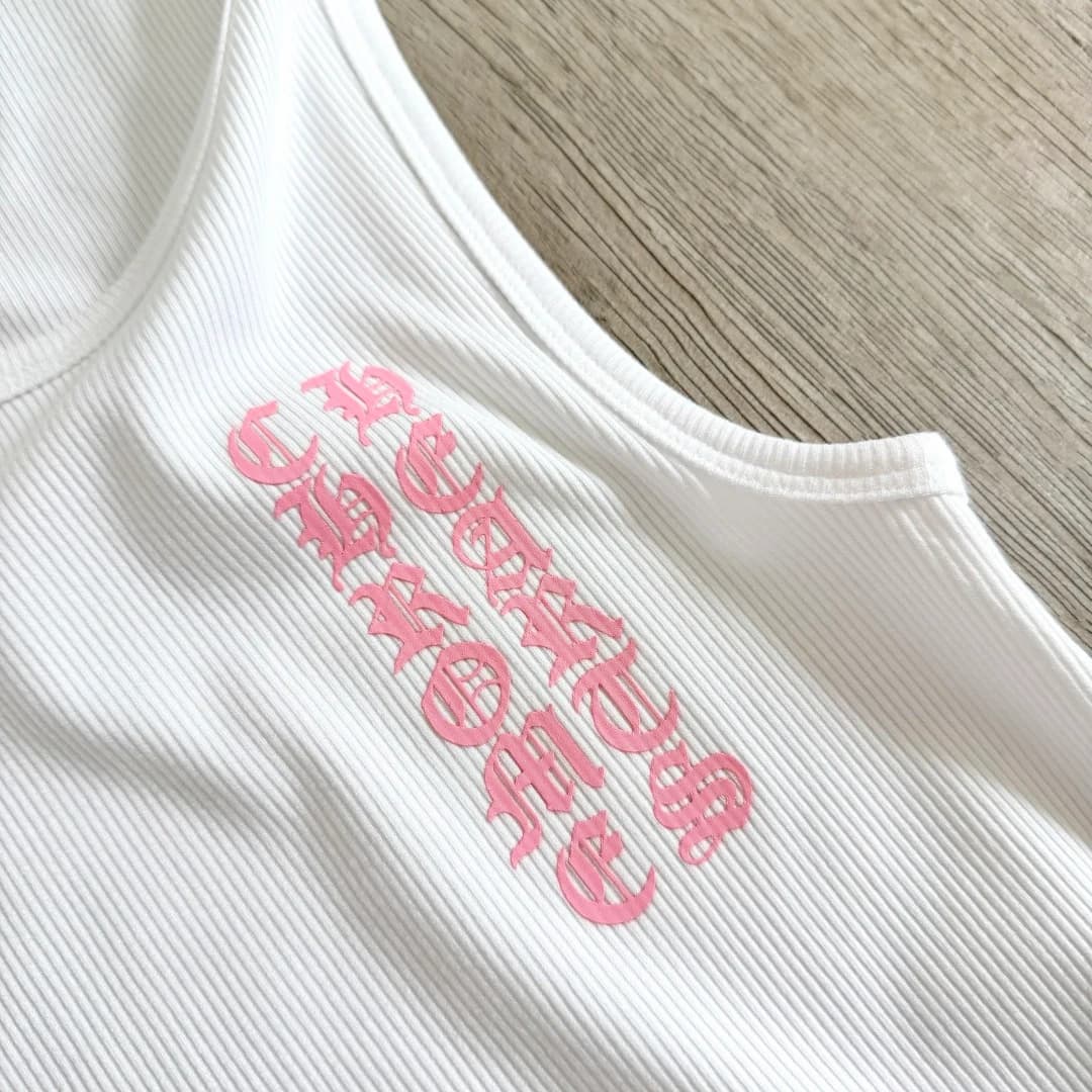 Крупный план розового готического принта на белой майке Chrome Hearts