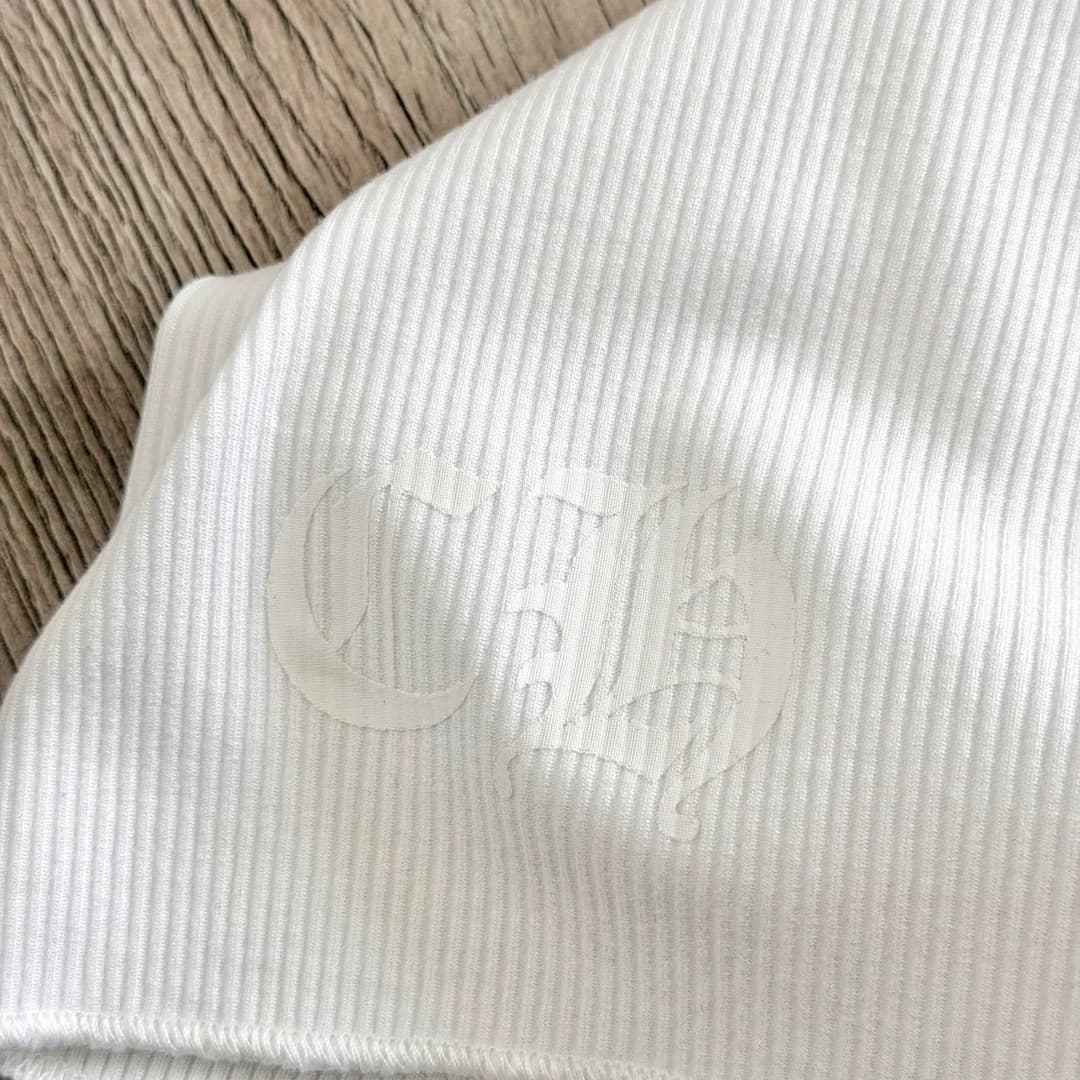 Крупный план белого тисненого принта на майке Chrome Hearts