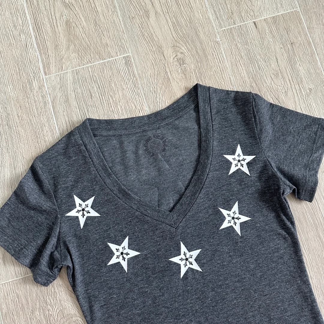 Деталь V-образного выреза серой футболки Chrome Hearts с принтом звезд
