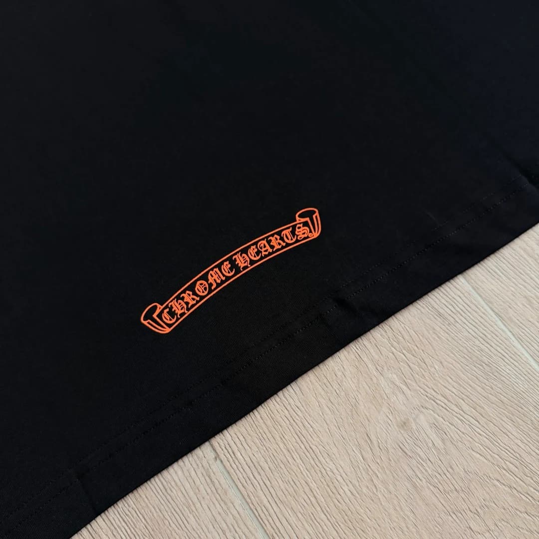 Деталь принта с логотипом Chrome Hearts на черной футболке