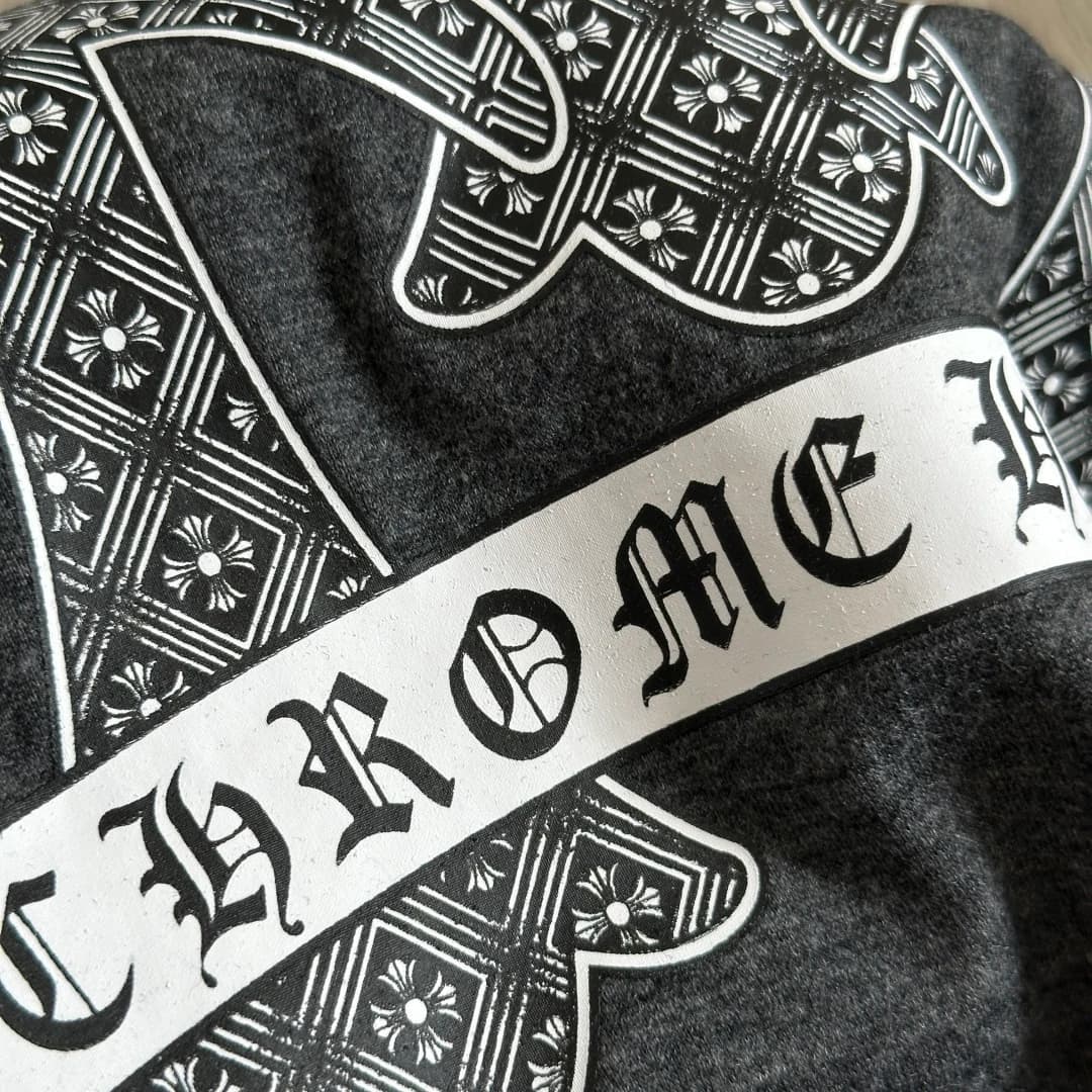 Деталь принта с надписью Chrome Hearts на фоне узорчатого креста