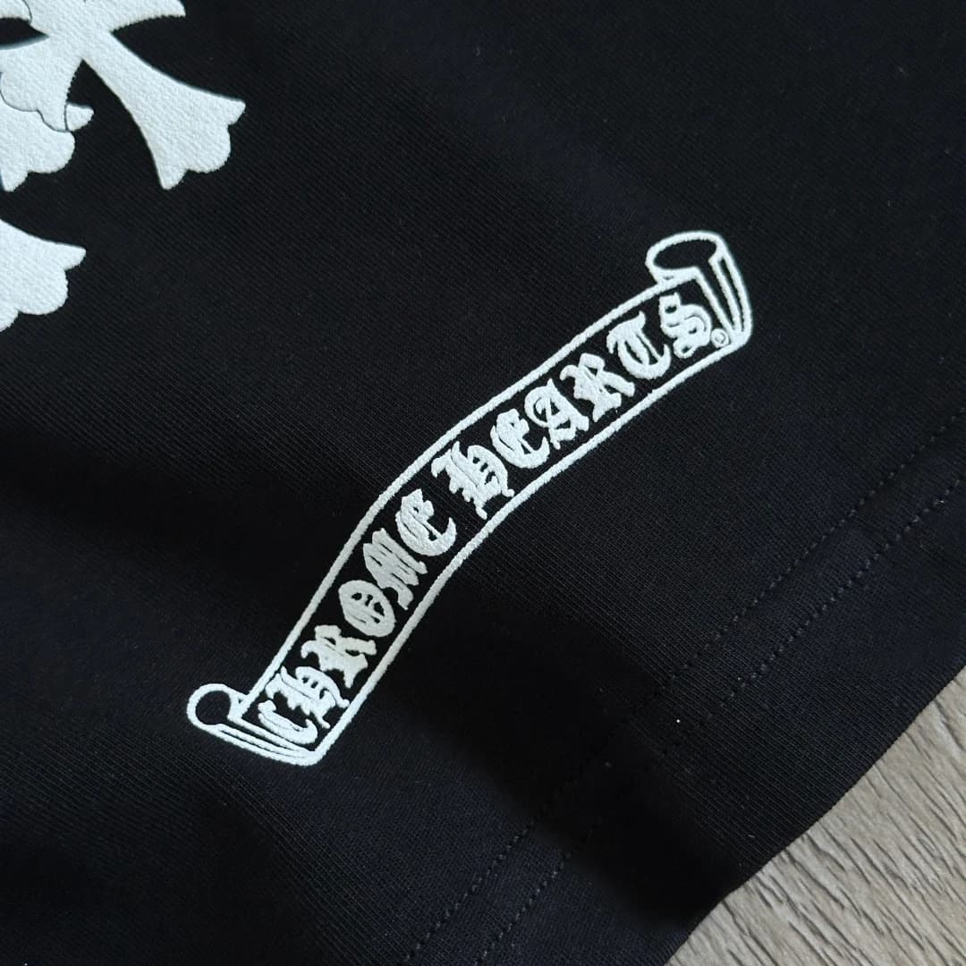 Крупный план логотипа-свитка Chrome Hearts на черной футболке