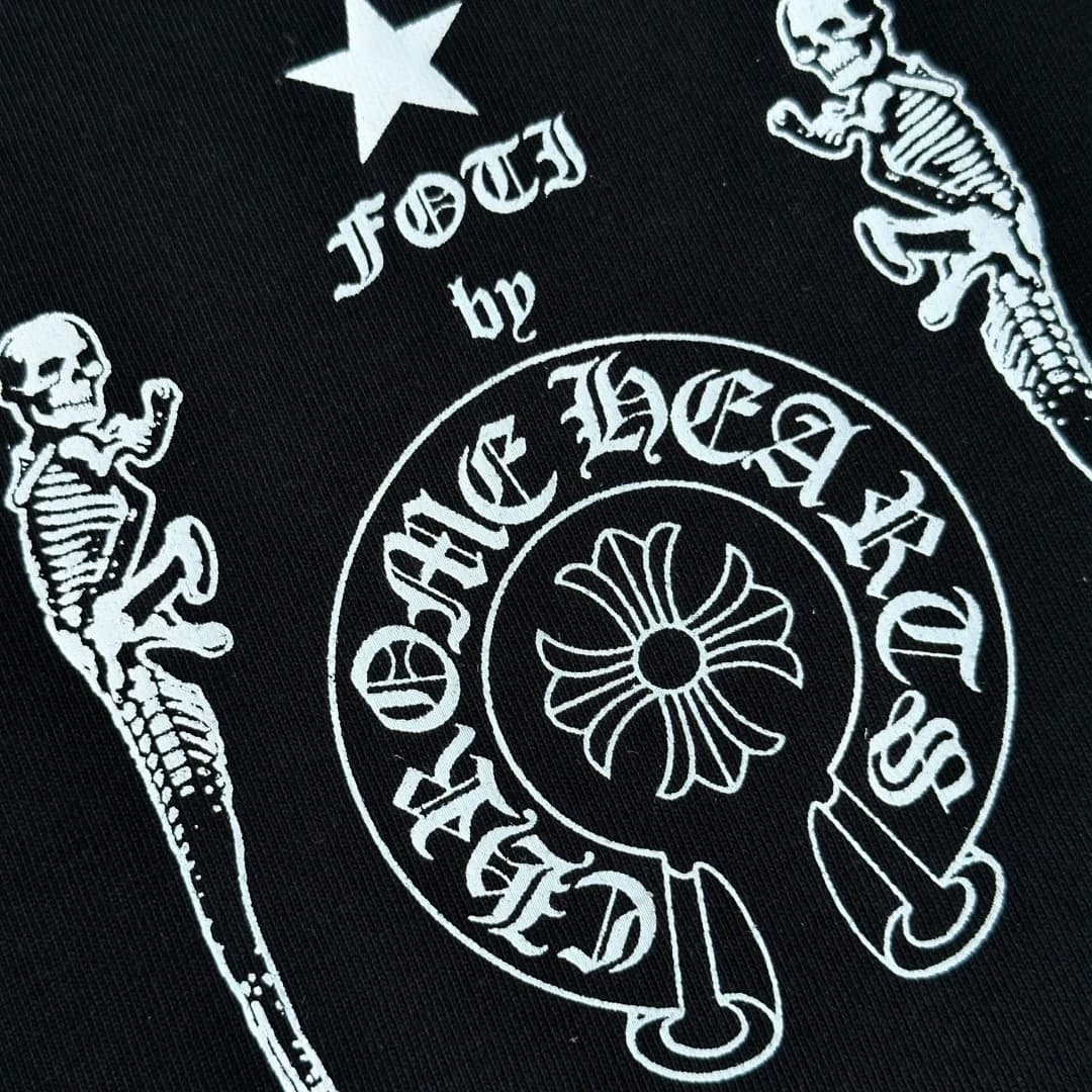 Крупный план принта Foti by Chrome Hearts на черной футболке