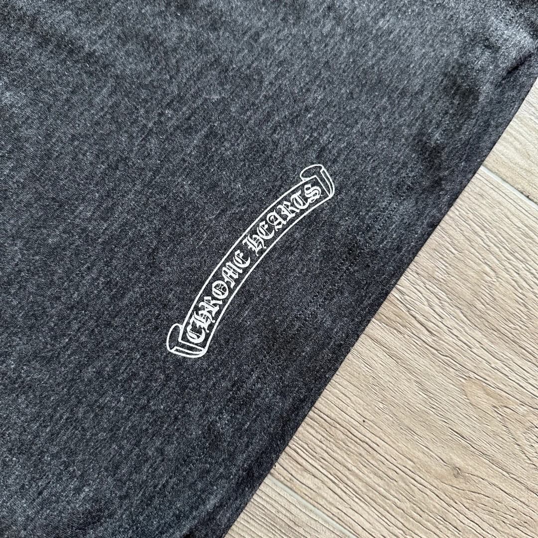 Деталь небольшого логотипа Chrome Hearts на серой футболке