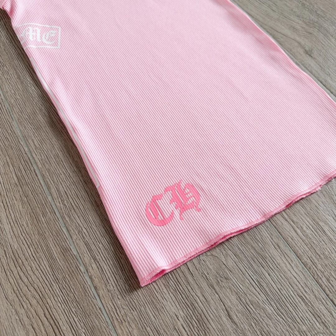 Деталь нижнего края с логотипом CH на розовом платье Chrome Hearts