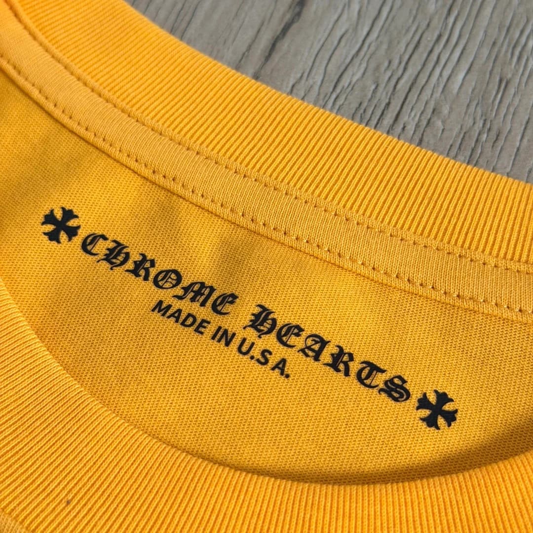 Логотип на внутренней стороне горловины жёлтой футболки Chrome Hearts