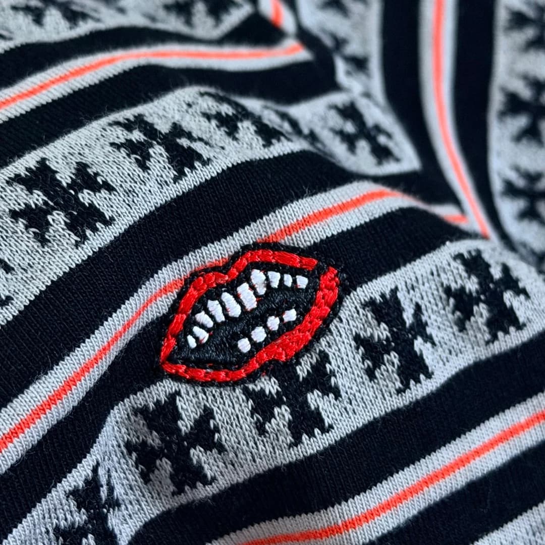 Крупный план вышивки в виде губ на футболке Chrome Hearts