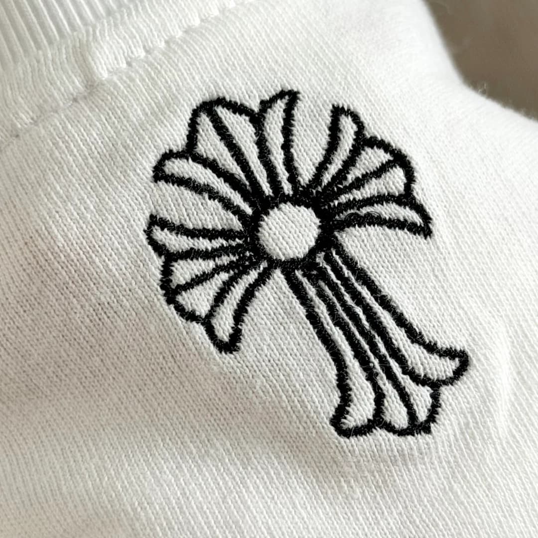 Деталь вышивки креста на белой футболке Chrome Hearts