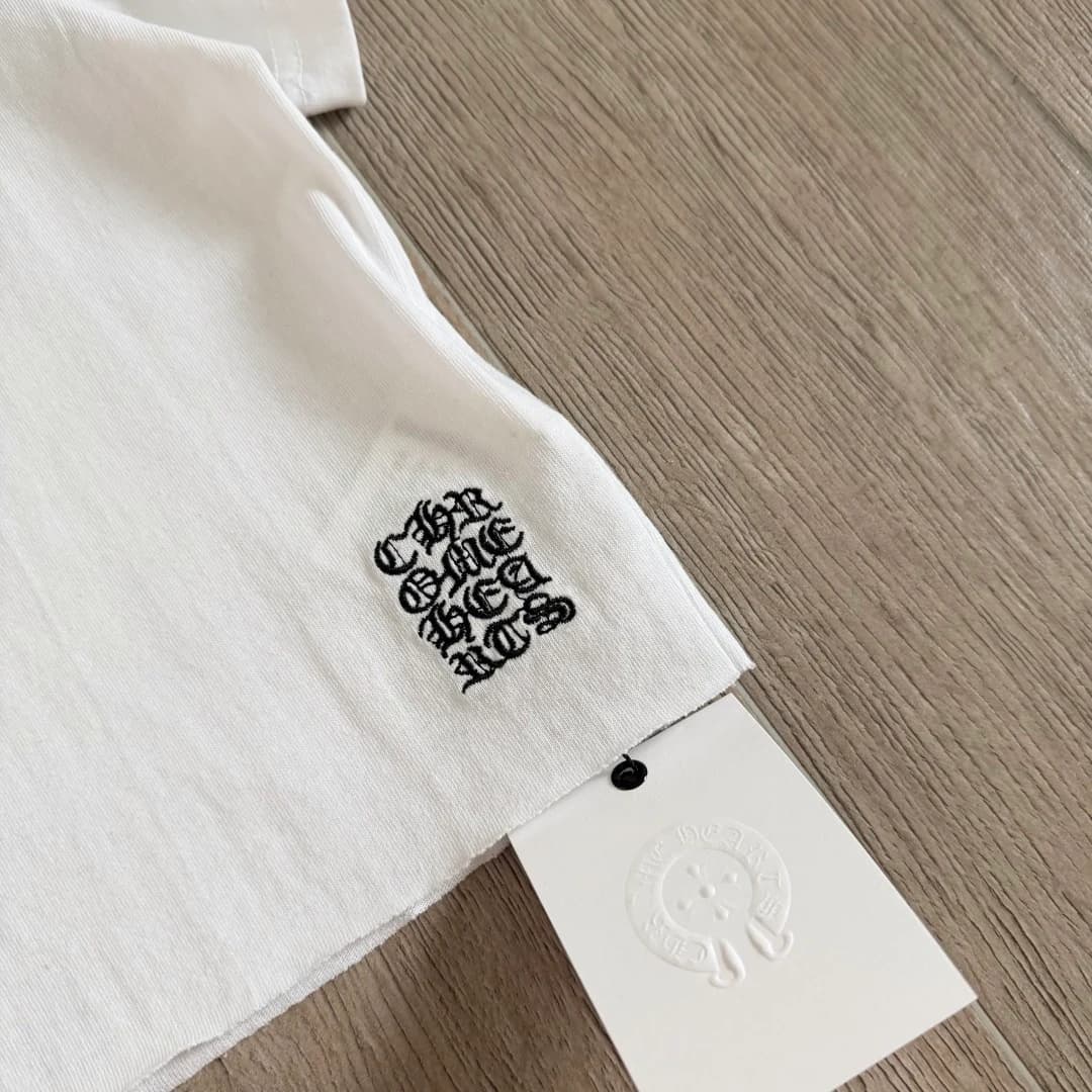 Вышитый логотип на нижней кромке белой футболки Chrome Hearts