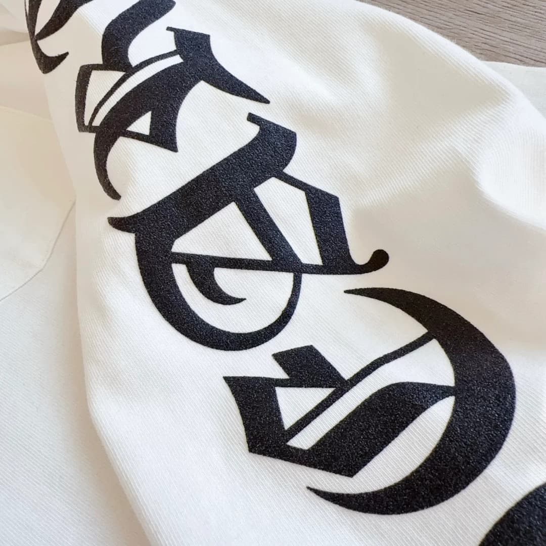 Принт в готическом стиле на рукаве белого лонгслива Chrome Hearts