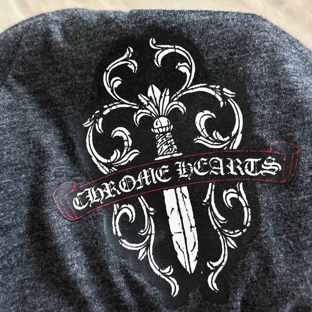 Деталь принта с логотипом на темно-серой футболке Chrome Hearts