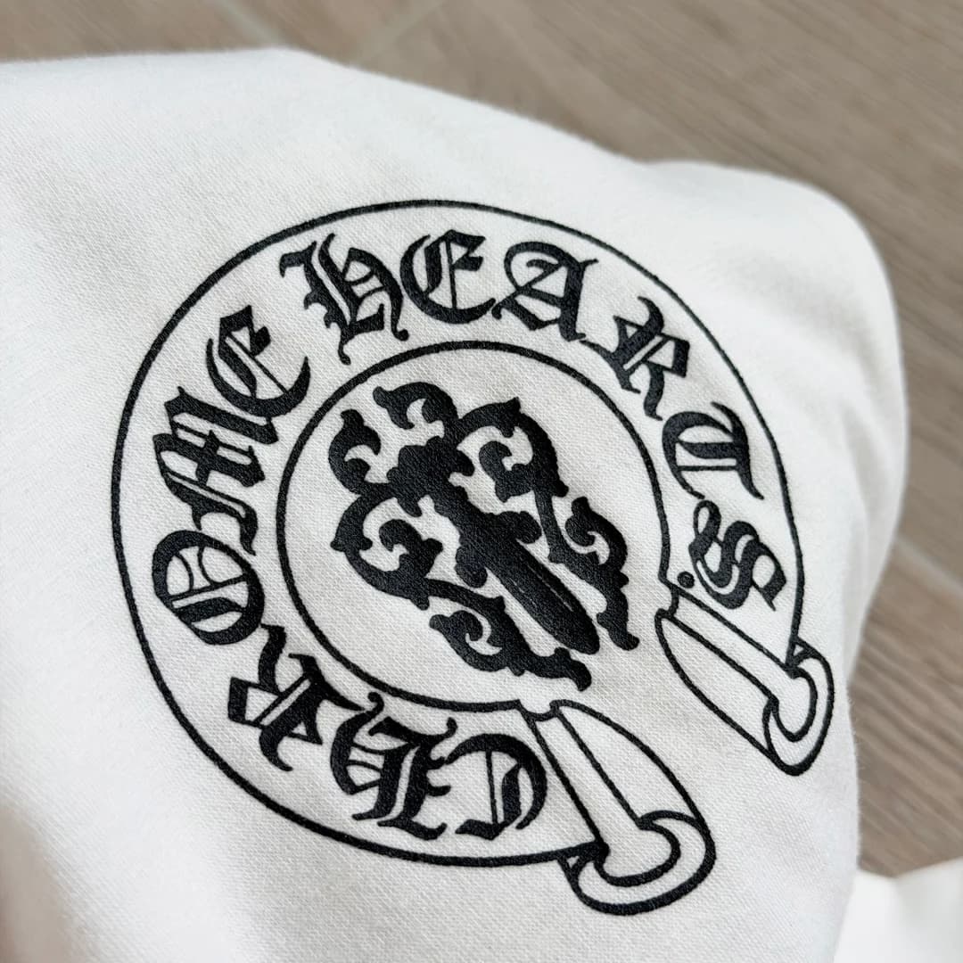 Круглый фирменный логотип на груди белой футболки Chrome Hearts