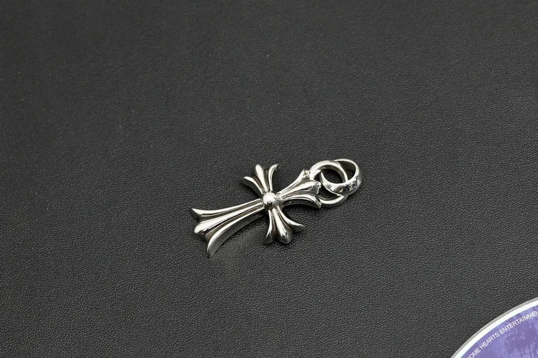 Серебряная подвеска-крест в диагональном ракурсе на тёмном фоне